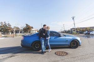 couple kissing by a blue mustang