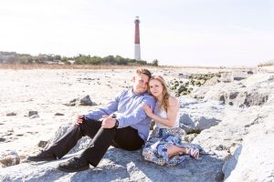 couple sitting on rocks by beach