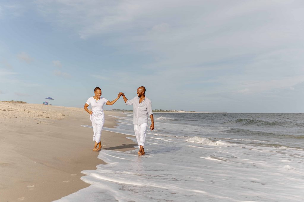 engaged couple walking on beach