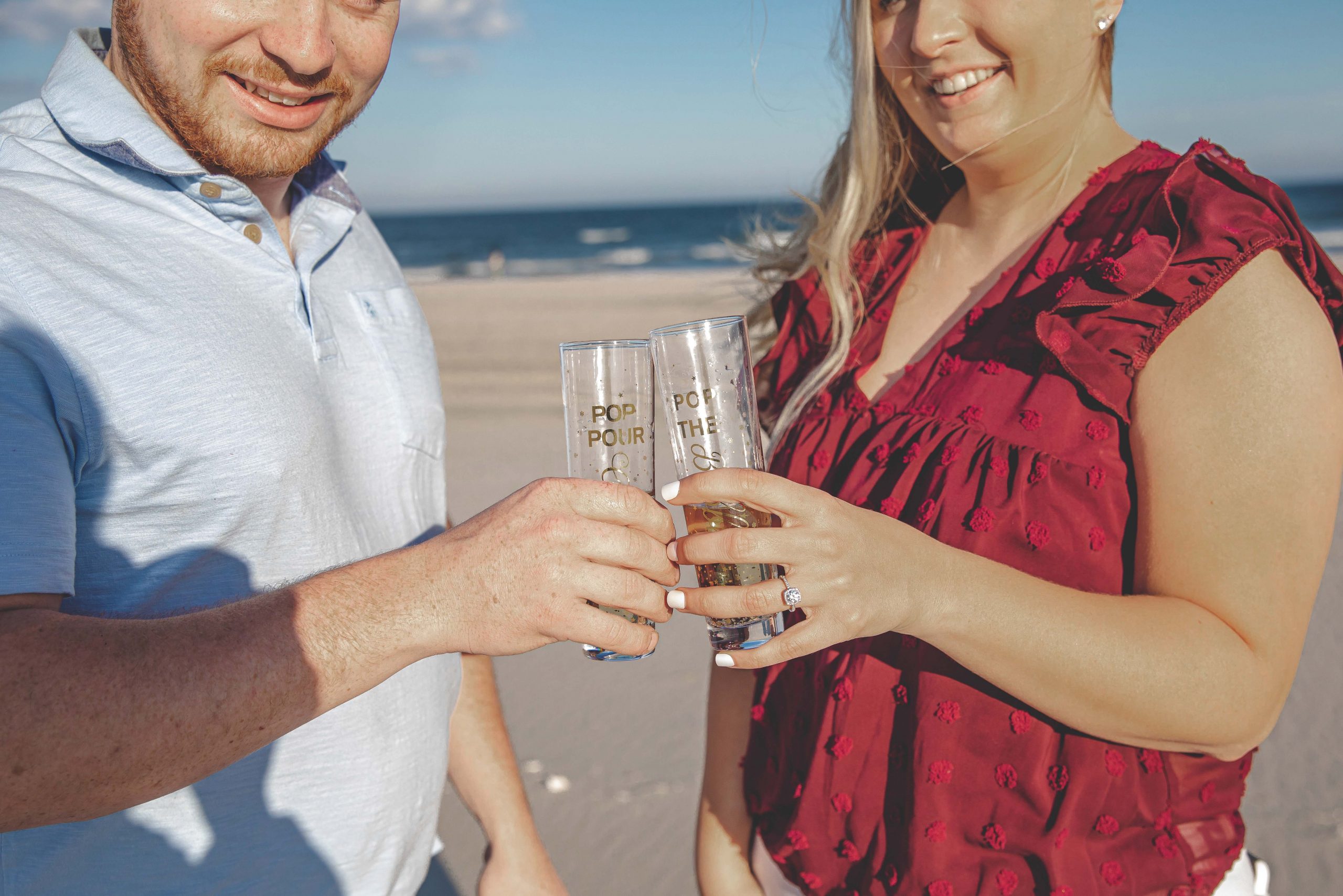 toasting a beach engagement