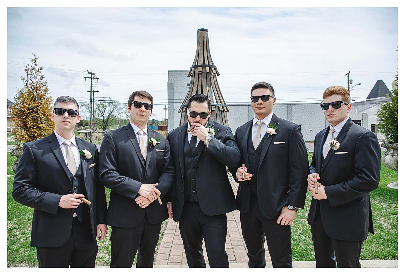 groom and groomsmen posing with cigars
