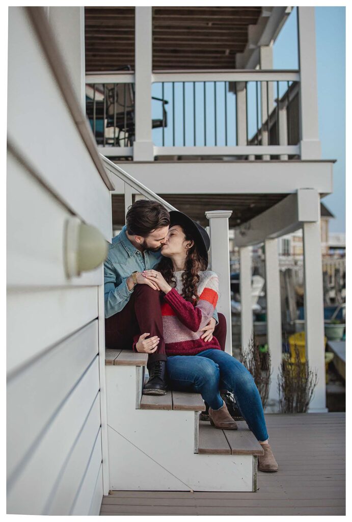 couple sitting on steps kissing Avalon Beach Engagement Session