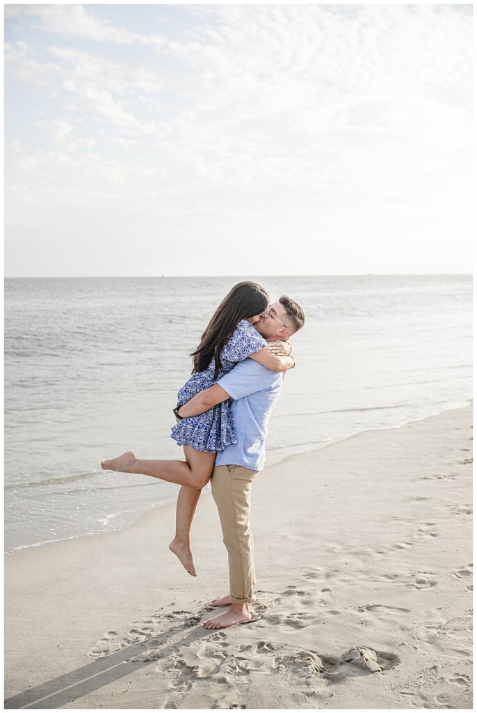 couple kissing on beach near cape may lighthouse