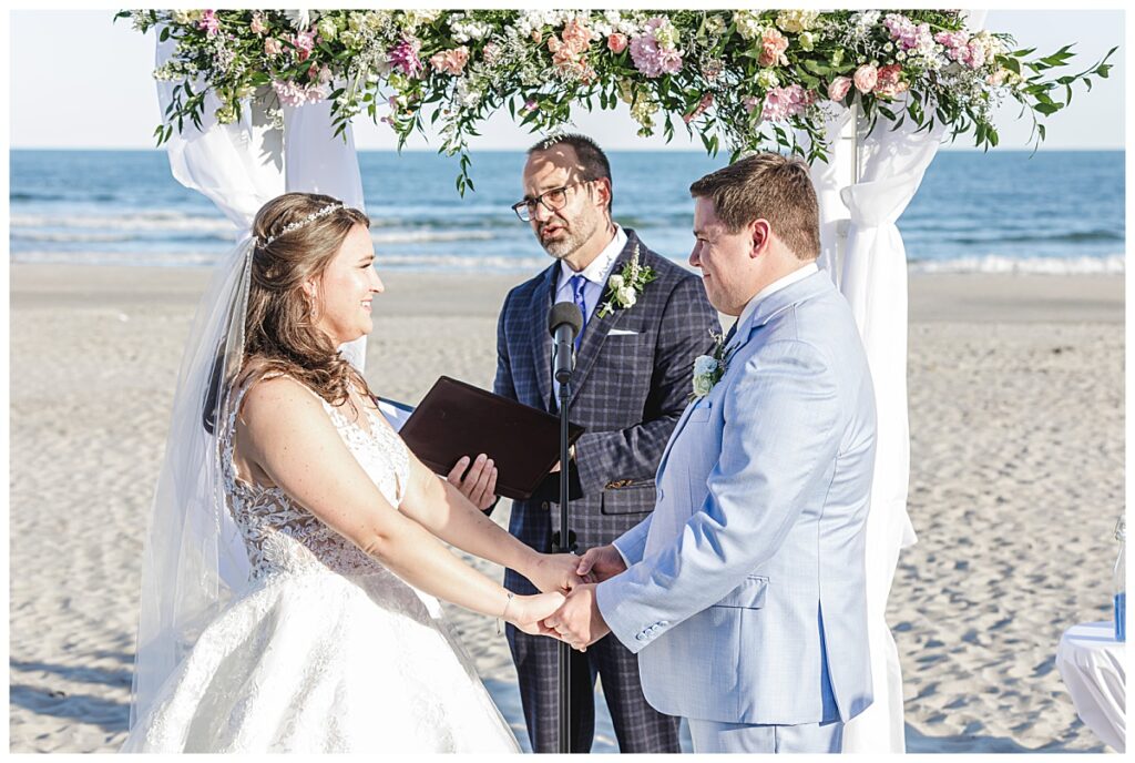 couple holding hands after exchanging rings on the beach