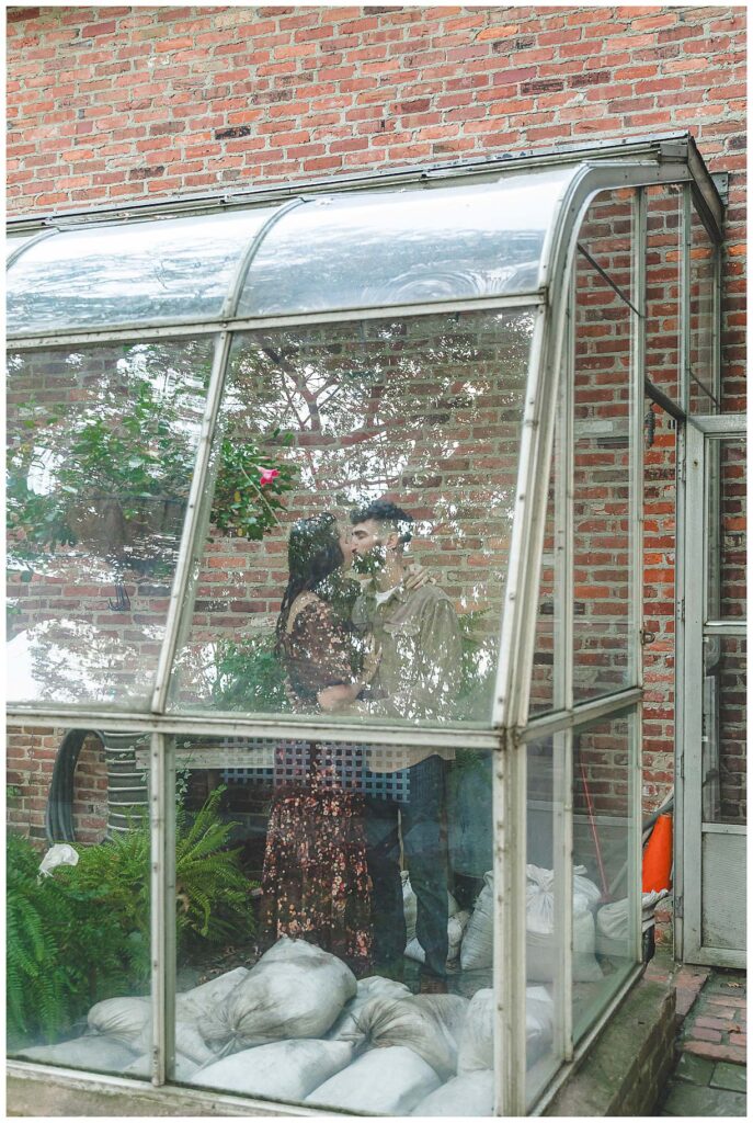 photo of the engaged couple standing in the greenhouse