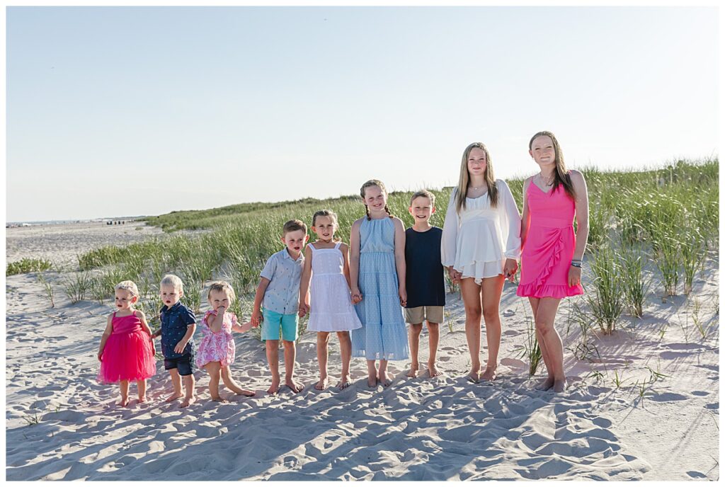 Cousins standing on beach in age order.