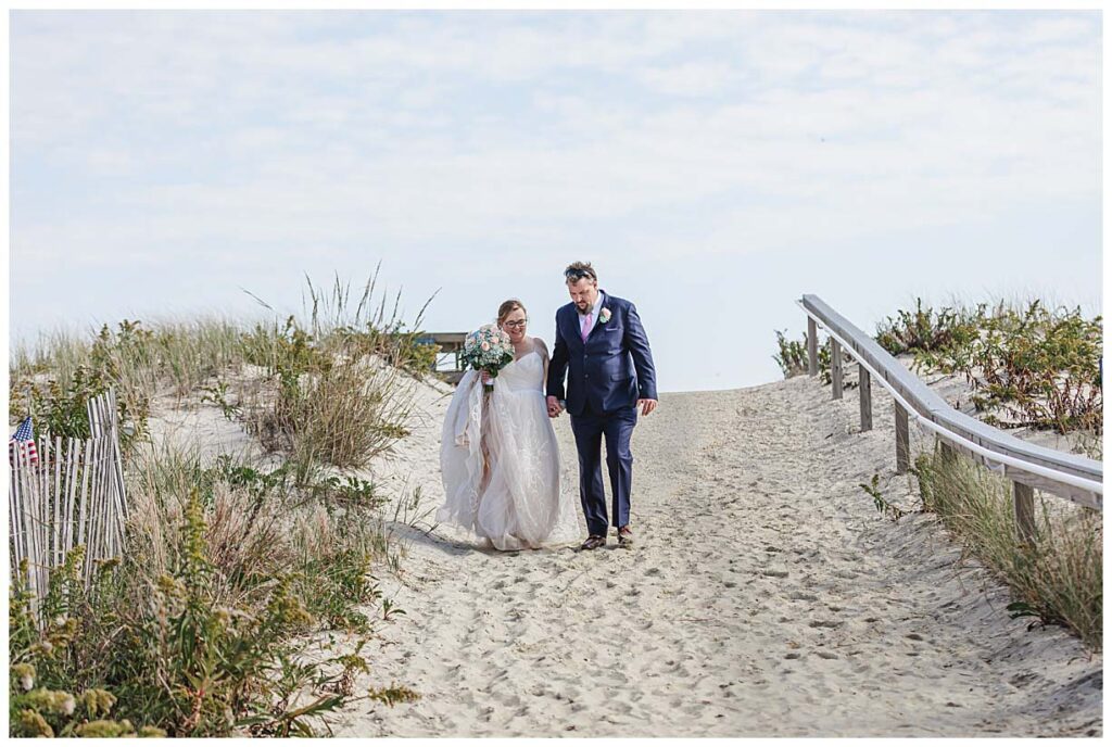 bride and groom walking down a beach path in LBI