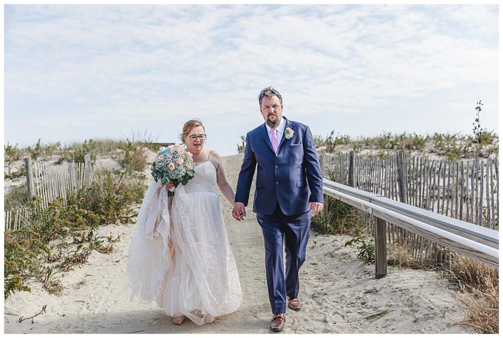 bride and groom walking on beach path before their LBI wedding
