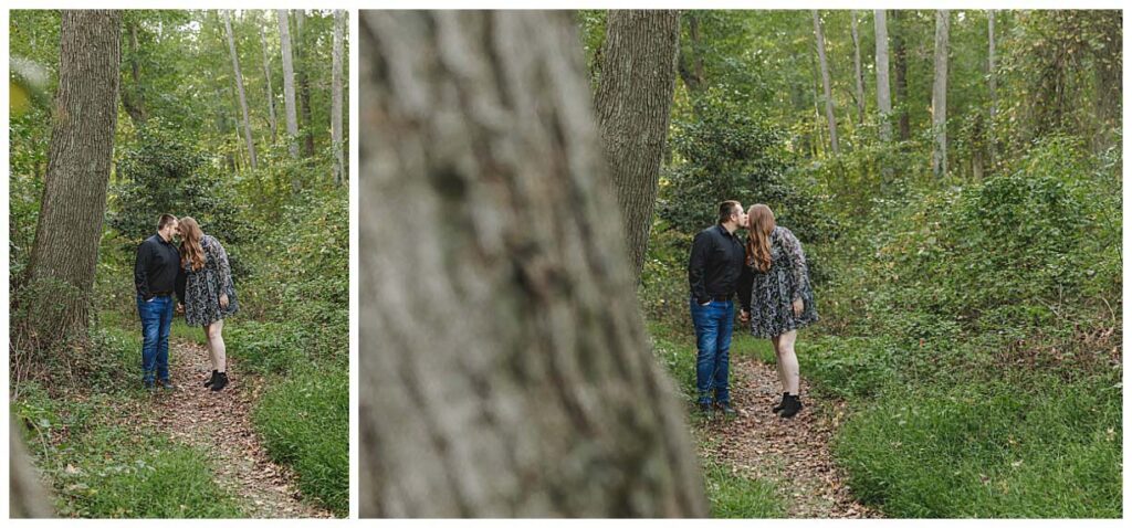 engaged couple posing on a wooded path for their engagement session