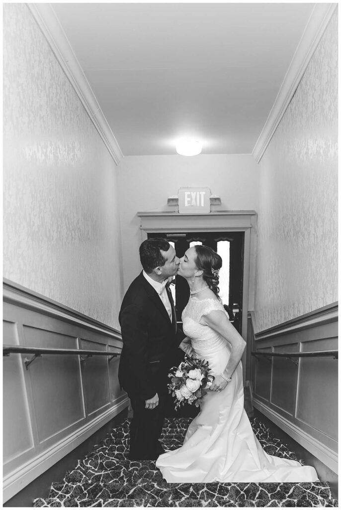 couple kissing in hallway after their wedding