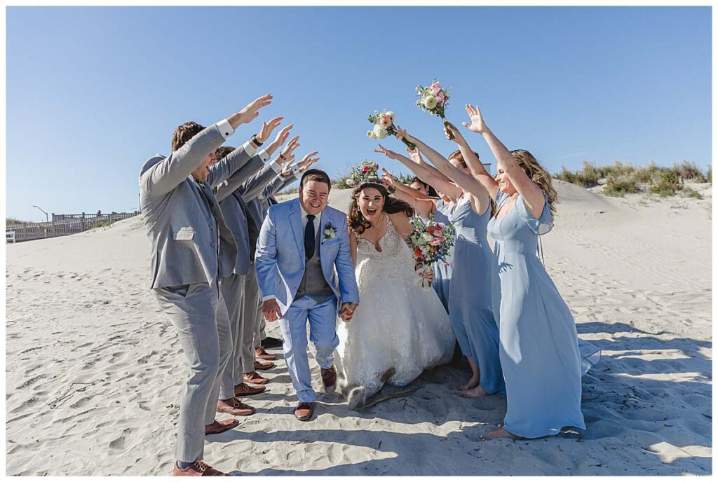 wedding couple running through a tunnel created by their wedding party in Avalon Nj