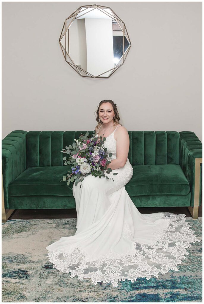 bride sitting on green couch in wedding gown at running deer golf club