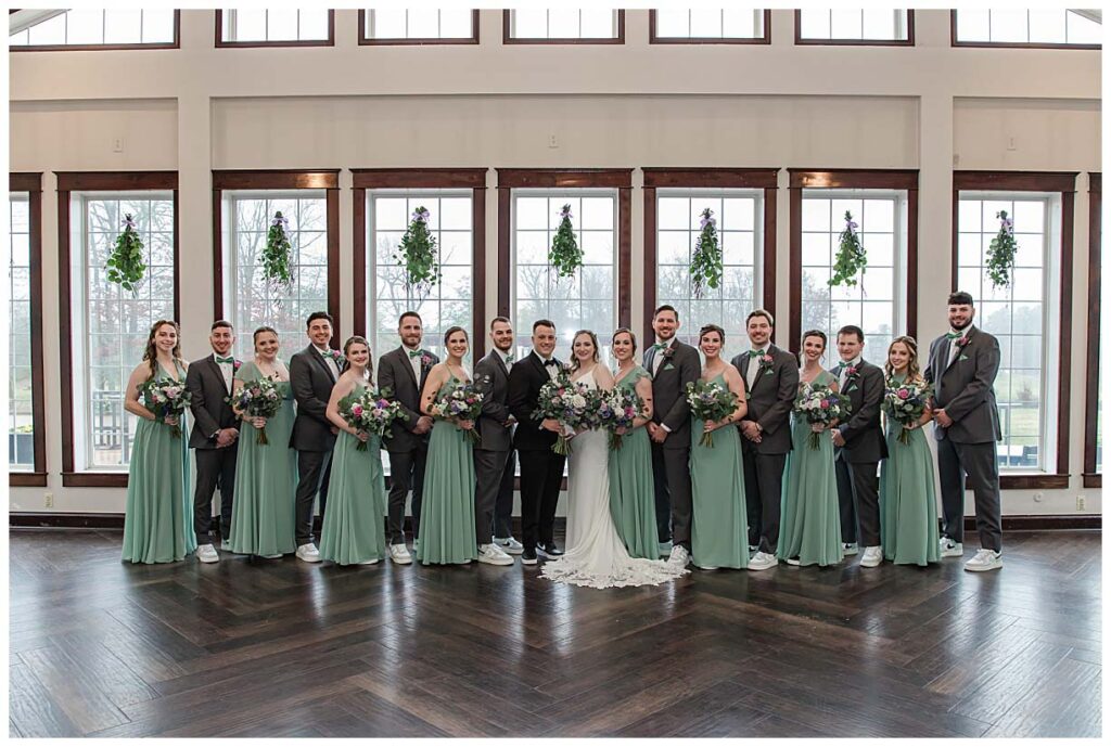 wedding party standing in front of big windows