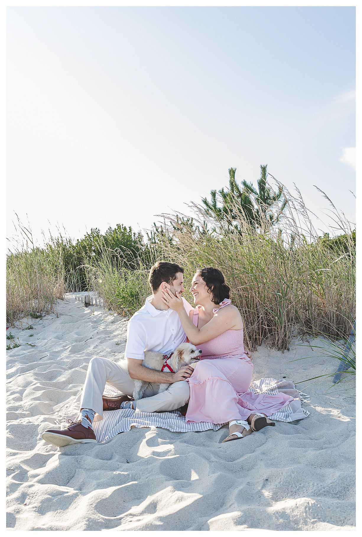 couple kissing with their puppy on the beach in cape may