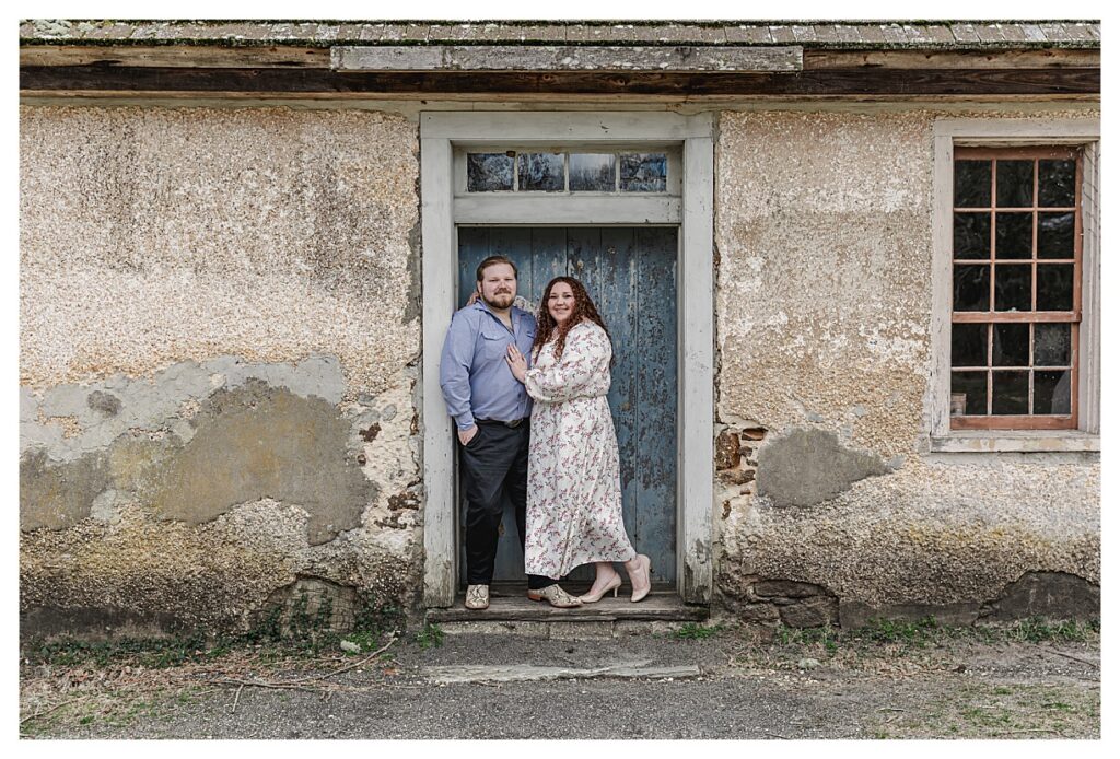 engaged couple standing by blue door