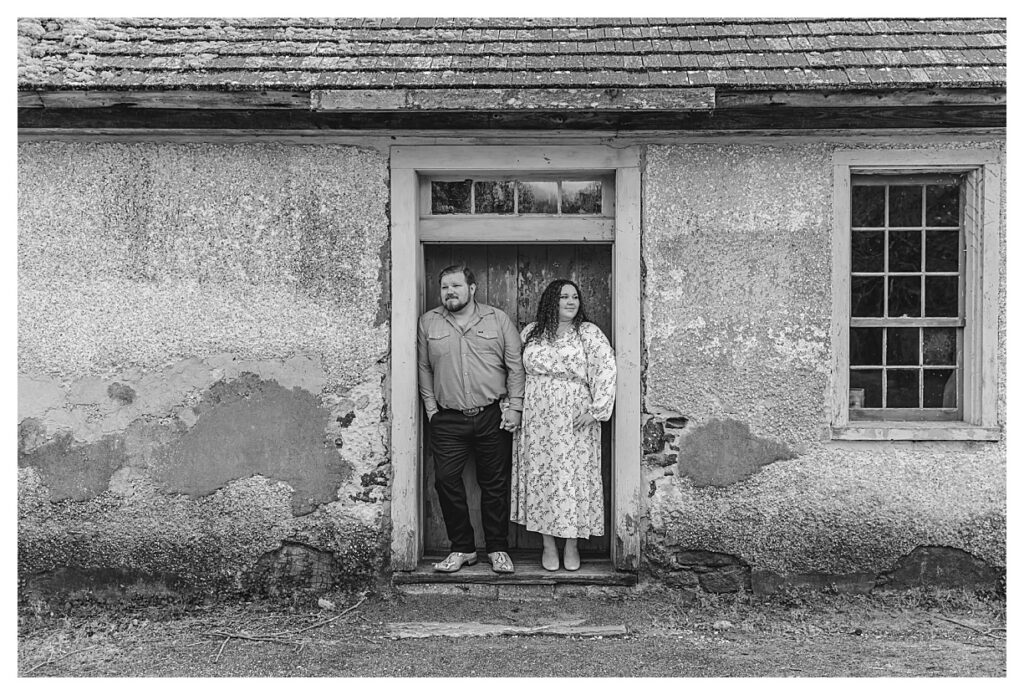 black and white photo of a couple standing by a door way