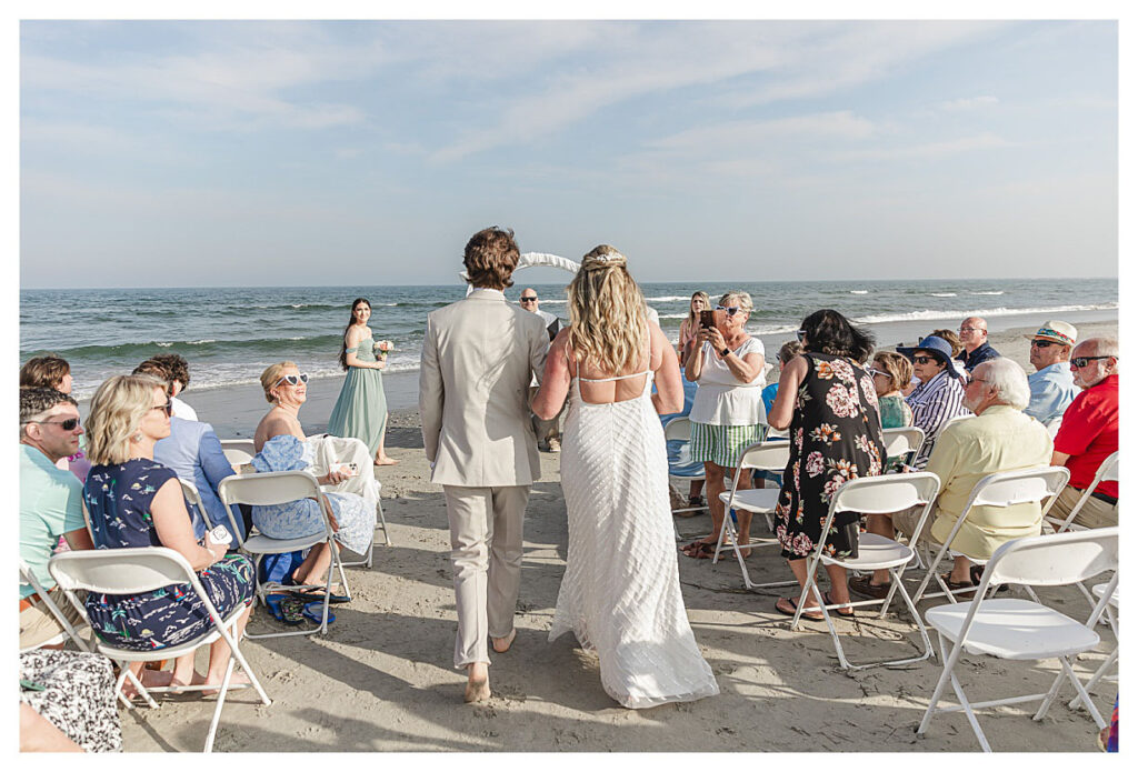 bride walking with her son down the asile at ther beach wedding