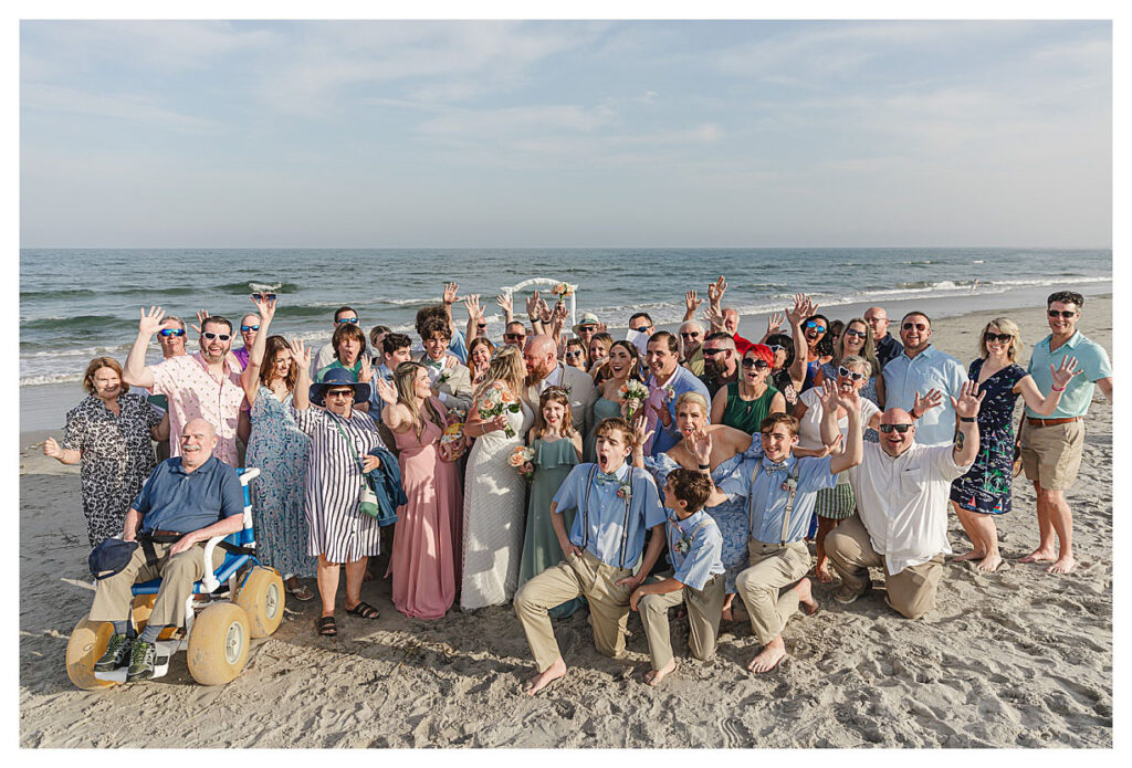 a large group of people celebrating a couple that just got married on the beach