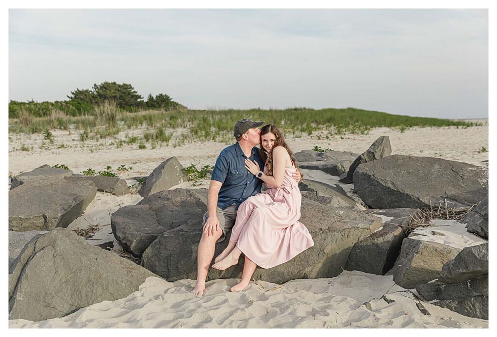 surprise proposal in Cape May. couple sitting on the rocks