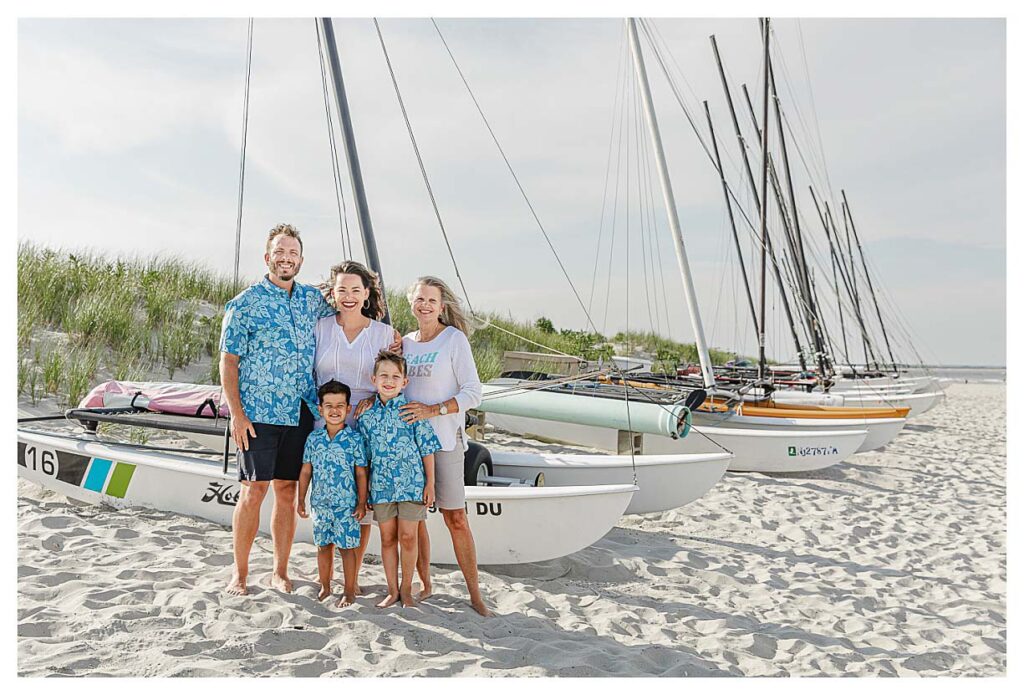 family standing in front of boats on the beach in ocean city nj