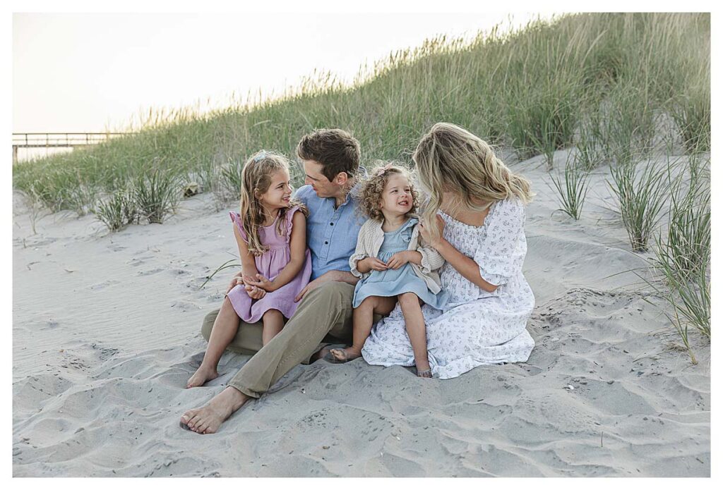 mom and dad talking to their kids while sitting on the beach in south jersey