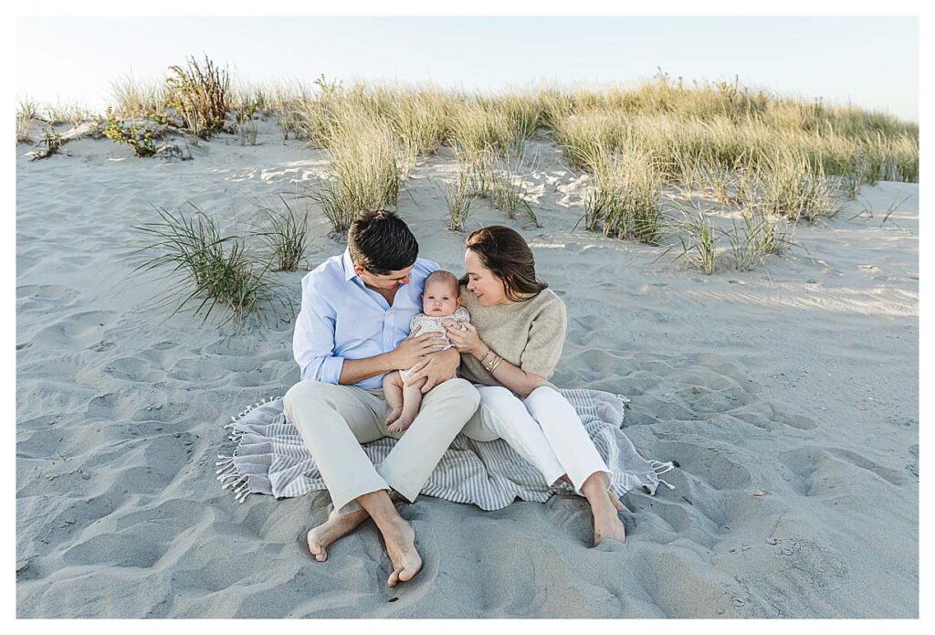 mom and dad enjoying their daughters first visit to the beach in ocean city nj