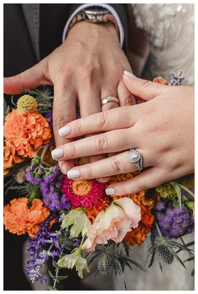 photo of the wedding rings on the brides wedding bouquet at the deauville inn